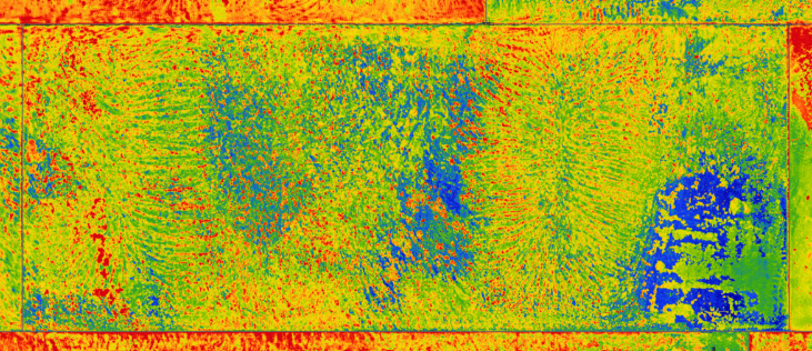 Ultrasonic thickness map of a tank floor plate rendered as a colour heatmap — greens and yellows across the bulk of the plate with blue thin-wall regions and red weld seams at the edges.